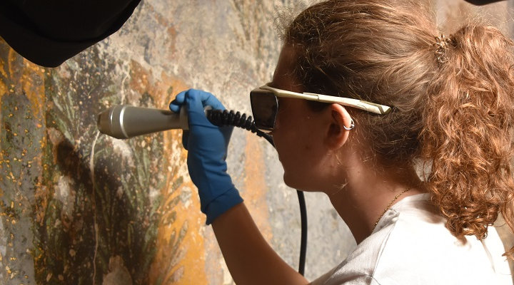 Restauratrice al lavoro su uno degli affreschi delle terme