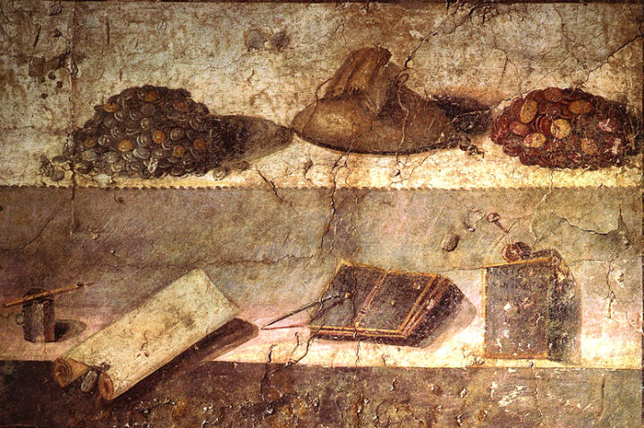 Museo Archeologico Nazionale di Napoli (inv. nr. 8598). Da Pompeii, Praedia di Iulia Felix - Quarto quadro con natura morta a decorazione di una parete tripartita di colore rosso e giallo. Su due ripiani figurano gli elementi caratteristici del commercio: sul ripiano superiore una borsa di tela contenente del denaro separa un gruzzolo di monete d'argento e d'oro a sinistra da un altro gruzzolo di monete d'oro a destra; sul piano inferiore figurano un calamaio in bronzo con stiletto, un rotolo di papiro con sigillo, ed infine due tavolette cerate, documenti di transazioni economiche.