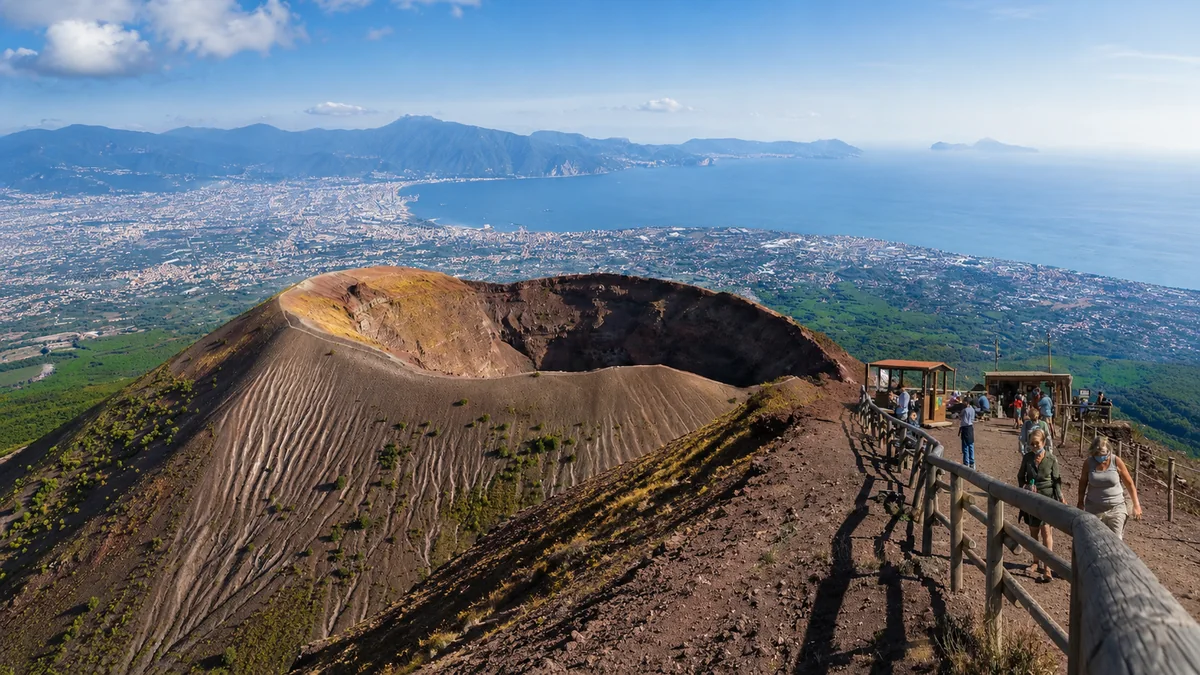 Visitors on the Mount Vesuvius crater trail with the Gulf of Naples in the background